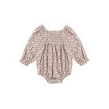 A baby long-sleeve romper with a dense beige and brown floral pattern, featuring a smocked bodice and ruffled sleeves, shown flat on a white background.