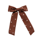 A brown fabric bow tie with white polka dots, presented on a clean white background.