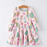 A pink long-sleeve dress with a colorful Christmas-themed print featuring the Grinch, Cindy Lou, Max the Dog, and Christmas decorations hanging on a wooden hanger against a light gray background.