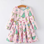 A pink long-sleeve dress with a colorful cartoon Grinch print, hanging on a wooden hanger against a light gray background.
