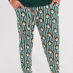 A person wearing dark green pajama pants with a vertical white stripe pattern and a repeating Santa Claus face motif, paired with a dark green long-sleeve top. The photo is cropped from the chest down against a plain white studio background.