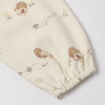 Close-up of the sleeve on our turkey romper featuring a repeating pattern of small turkeys and delicate wildflower illustrations. The fabric is gathered at the bottom into an elastic cuff, shown against a clean white background. 