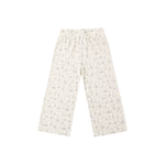A pair of wide-leg pants in a warm off-white or cream base fabric with a dense, small-scale floral print in muted green and gray tones, shown flat against a solid white background.