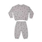 A two-piece children's loungewear set in light gray, featuring a long-sleeve top and matching pants, both printed with a small black tree motif.