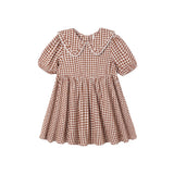 A toddler girl's short-sleeve dress in a brown and white gingham check pattern, featuring a large Peter Pan collar with white lace trim, a gathered waist, and a flared skirt.
