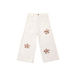 Off-white wide-leg cropped pants with three brown and pink floral applique details on the front, displayed flat against a solid white background.