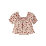 A short-sleeve babydoll blouse with a smocked square neckline, featuring a small red and green floral print on a light beige background.