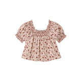 A short-sleeve babydoll blouse with a smocked square neckline, featuring a small red and green floral print on a light beige background.
