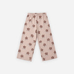 A pair of children's cropped pants in a dusty pink color, featuring an all-over print of small brown flower motifs, laid flat against a light gray background.