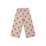 A pair of children's wide-leg pants in a light beige or dusty pink color, featuring an all-over brown flower pattern, displayed flat against a solid white background.