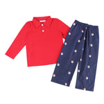 A two-piece children's outfit set featuring a bright red long-sleeve polo shirt and navy blue pants with a repeating Santa Claus face print, displayed on a clean white background.