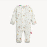 A baby long-sleeve footless one-piece romper in off-white, decorated with a whimsical woodland print of trees, birds, flowers, and stars. The romper features a colorful striped inner collar and a small red tag on the lower leg, shown against a plain light background.