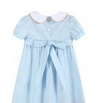 A light blue short-sleeve girl's dress with a white Peter Pan collar outlined in orange, featuring a button front, a matching waist tie bow, and a flared skirt.