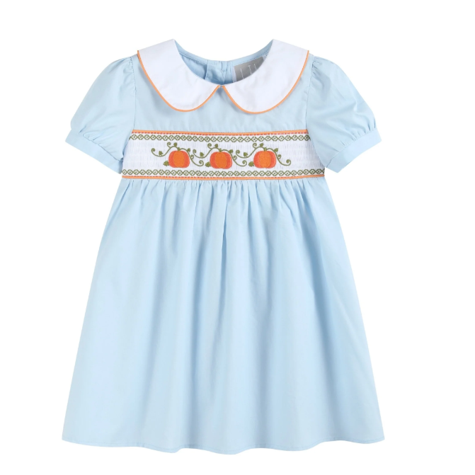 A light blue baby girl's dress with a white Peter Pan collar, short puff sleeves, and a smocked chest panel featuring three orange pumpkins and green vines.