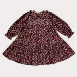 A long-sleeve babydoll dress with a ruffled collar and an all-over floral print, laid flat against a light gray background.