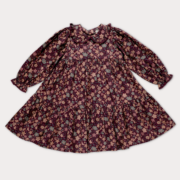 A long-sleeve babydoll dress with a ruffled collar and an all-over floral print, laid flat against a light gray background.