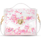 A clear vinyl handbag filled with tiny peppermint and gingerbread house confetti, a gold heart-shaped clasp, and a clear handle, shown on a white background.