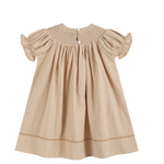 A beige baby dress with vertical stripes, featuring short ruffled sleeves, a smocked bodice, and a button closure at the back, shown against a plain white background.