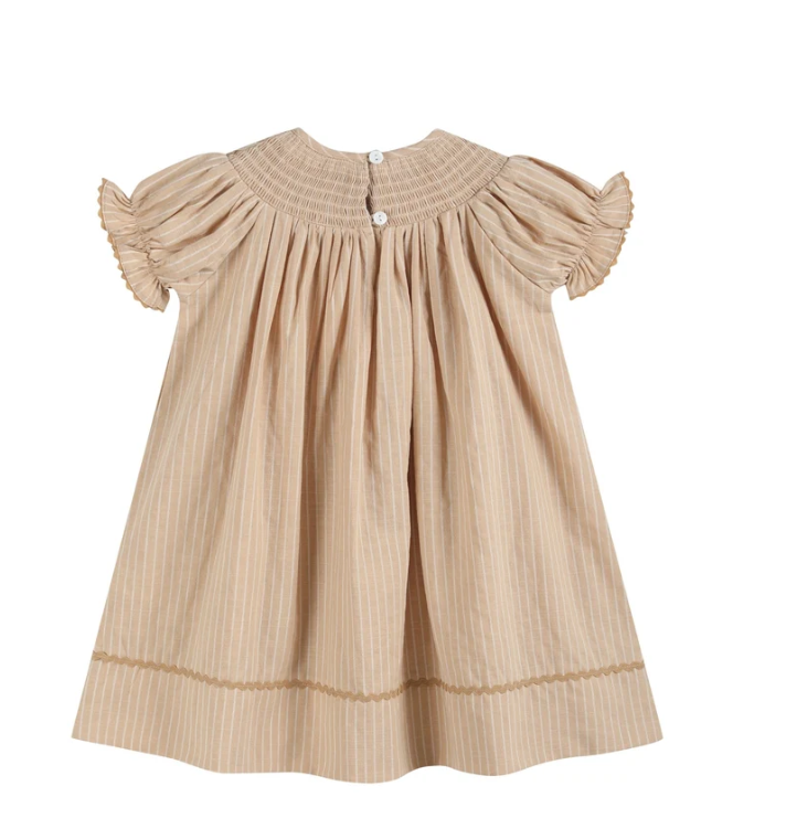 A beige baby dress with vertical stripes, featuring short ruffled sleeves, a smocked bodice, and a button closure at the back, shown against a plain white background.