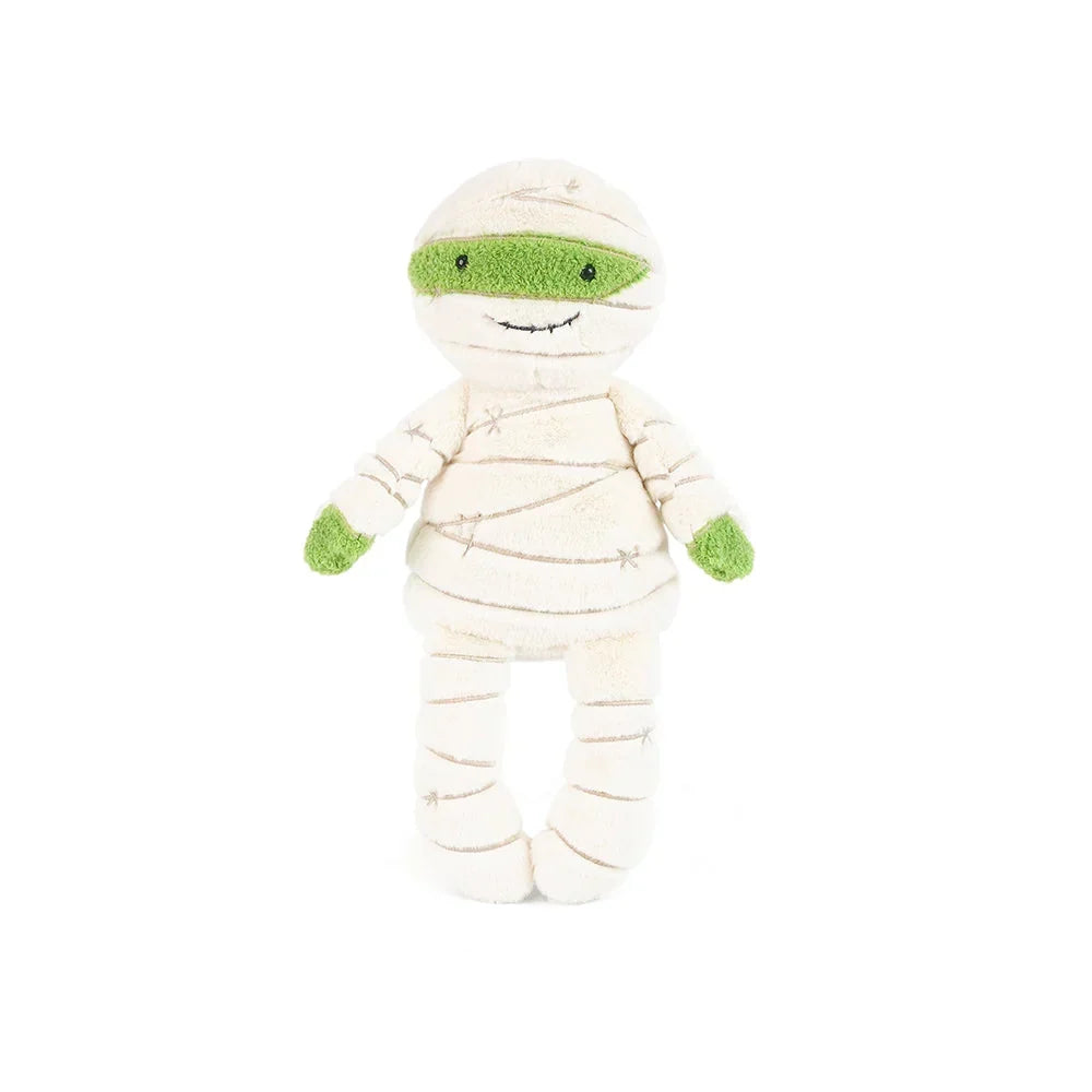 A plush mummy doll wrapped in cream-colored fabric bandages with bright green accents on the eyes, hands, and feet, set against a plain white background.