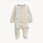 A baby footed sleeper with long sleeves and an all-over whimsical animal print in pastel blue, pink, and orange on a cream background, shown flat on a light gray background.