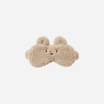 A pair of beige teddy-textured sleep masks shaped like a bear face, shown against a solid light gray background.